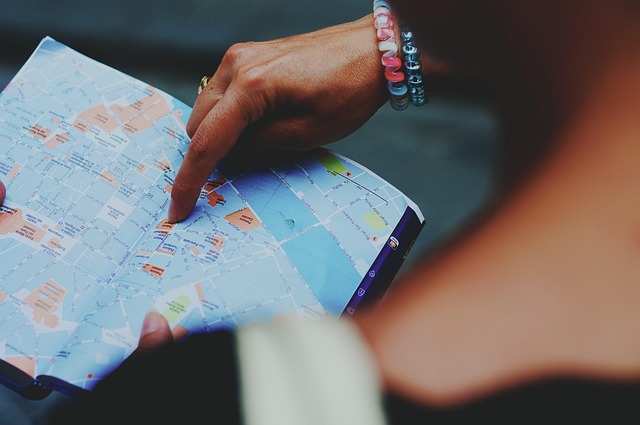 traveller reviewing route on phone with paper map